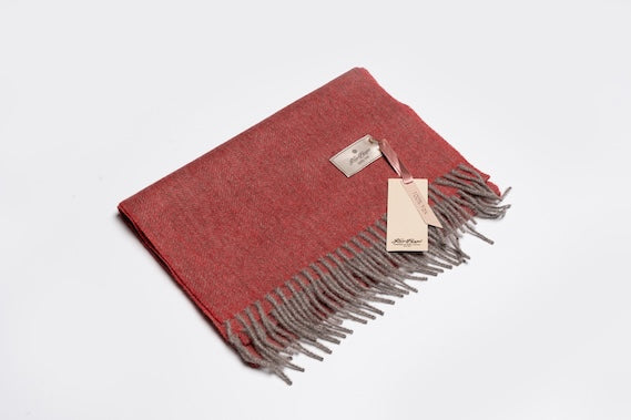 Red and grey 100% yak wool scarf with soft woven texture and fringe edges, showcasing natural warmth and minimalist sustainable design.