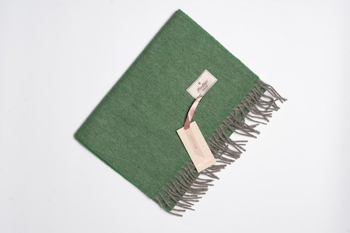 Green and grey 100% yak wool scarf with soft woven texture and fringe edges, showcasing natural warmth and minimalist sustainable design.
