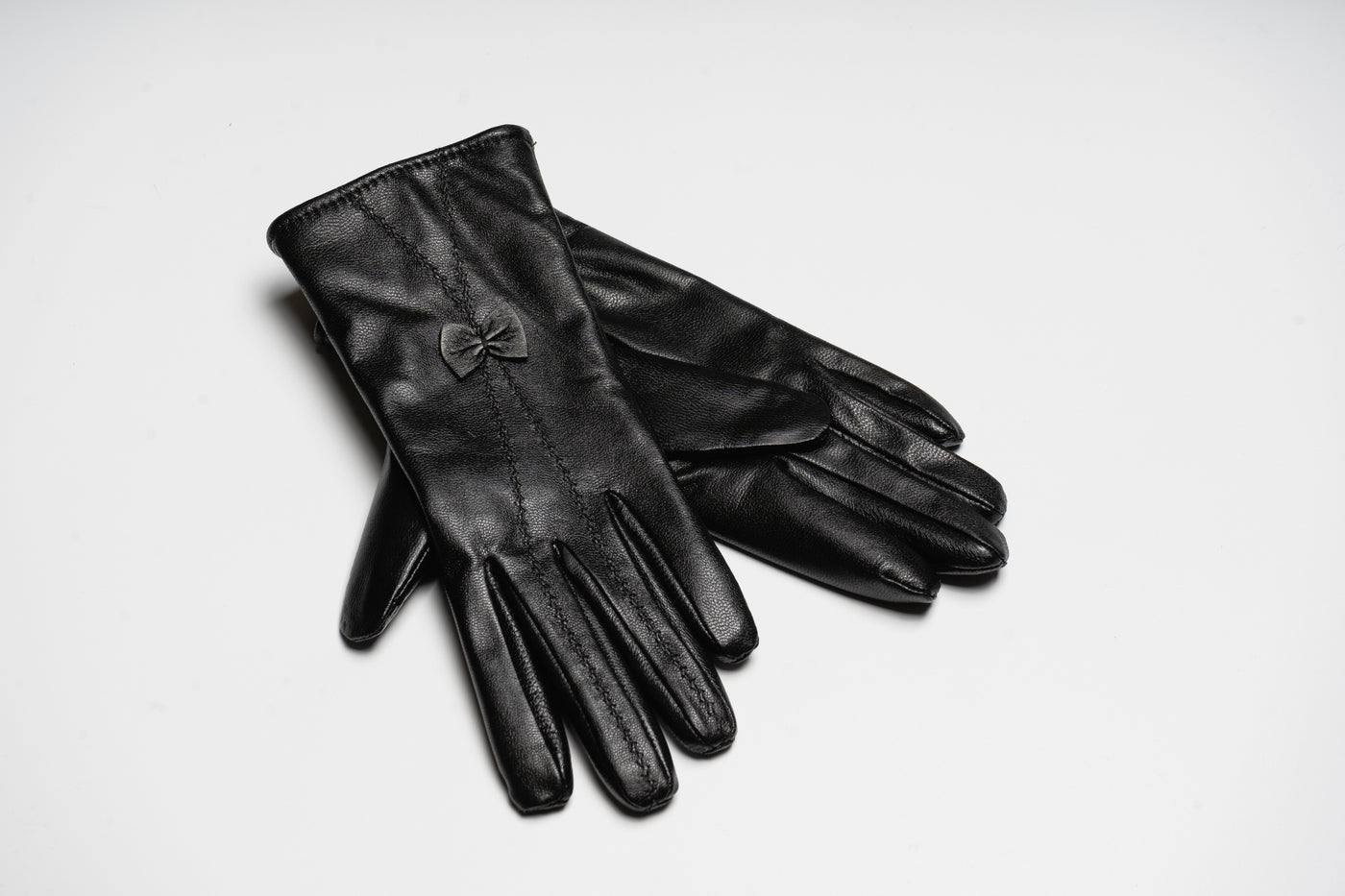 “Black women’s leather gloves with fine stitching and bow detail, elegant soft natural leather design for warmth and style”