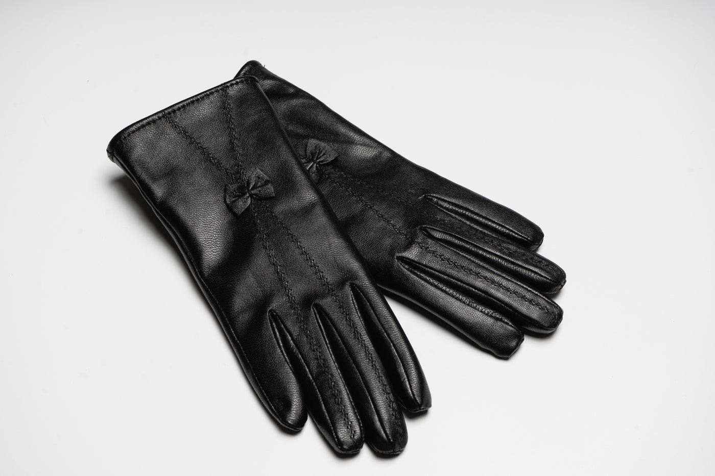 “Black women’s leather gloves with fine stitching and bow detail, elegant soft natural leather design for warmth and style”