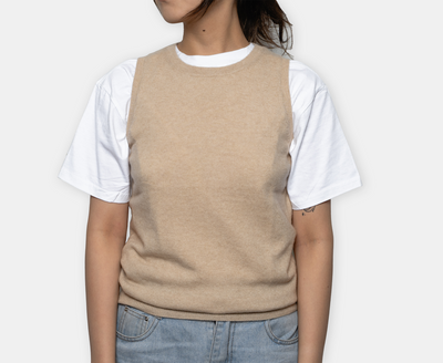 Beige crew neck cashmere vest made from 100% Mongolian cashmere, styled over a white T-shirt for a minimalist and elegant look.