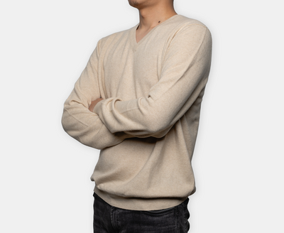 Men’s beige V-neck cashmere sweater with soft knit texture and minimalist design, offering lightweight warmth and refined sophistication.
