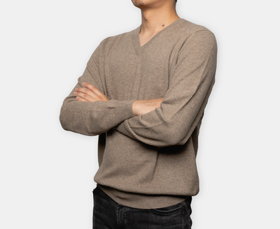 Men’s beige V-neck cashmere sweater with soft knit texture, offering lightweight warmth, natural softness, and classic minimalist elegance.