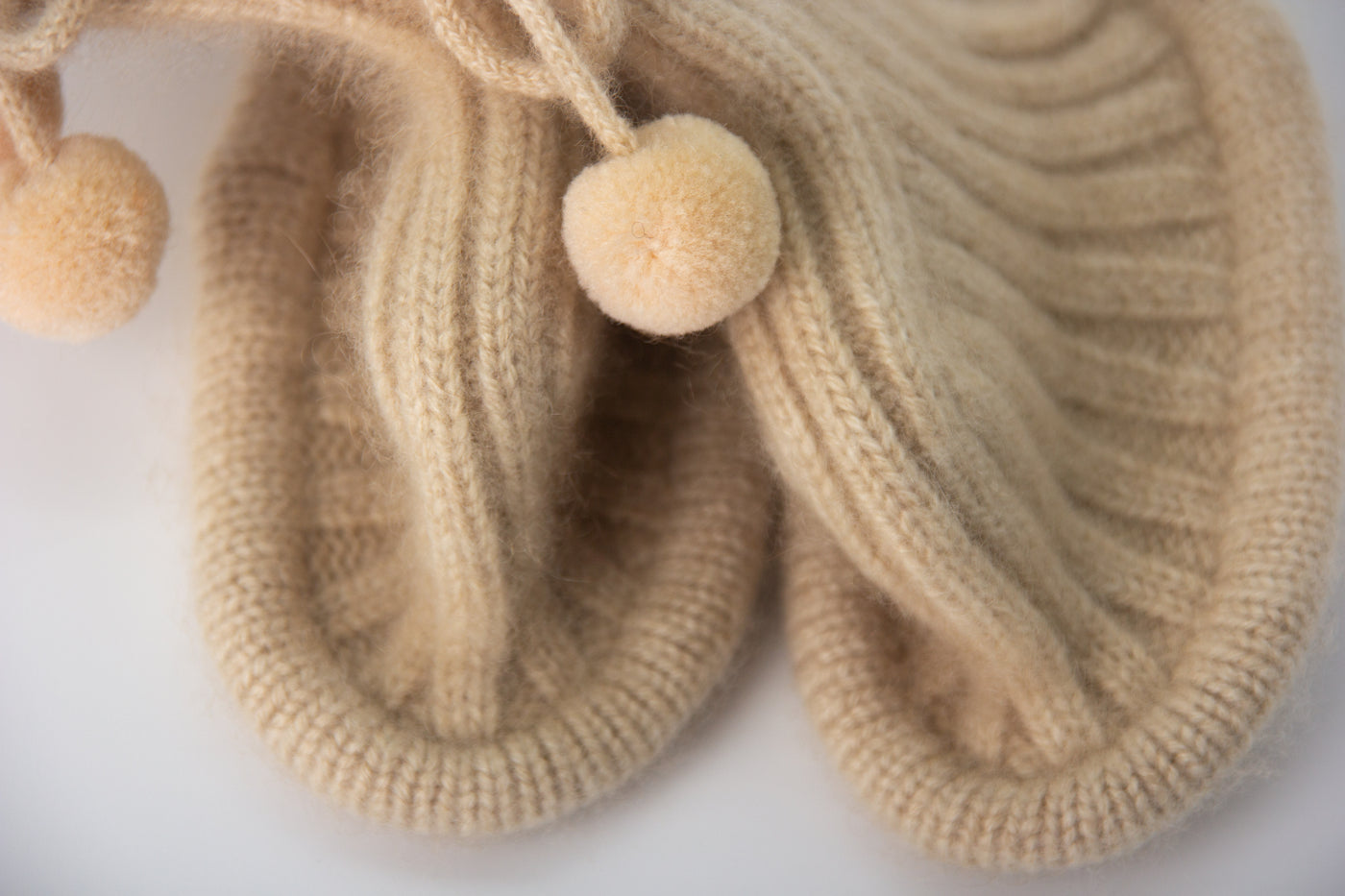“Beige pure Mongolian cashmere baby booties with ribbed knit design and pom-pom ties, soft and breathable for newborn warmth”