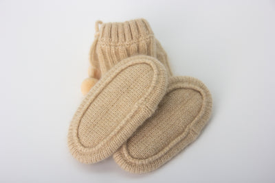 “Beige pure Mongolian cashmere baby booties with ribbed knit design and pom-pom ties, soft and breathable for newborn warmth”