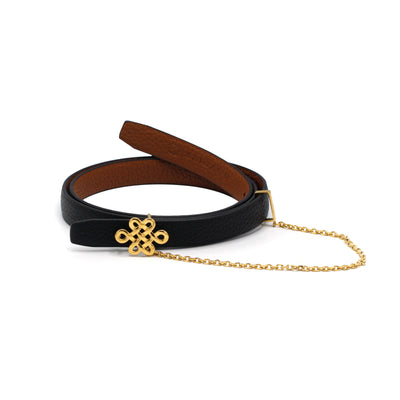 Women’s black leather belt with a gold Ulzii knot buckle and delicate gold-tone chain detail, symbolizing tradition and elegance.
